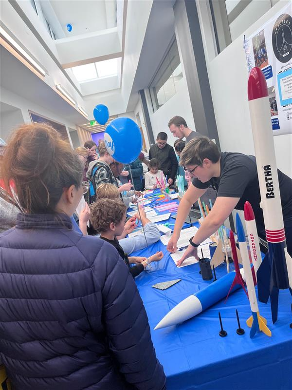 Kids at table being shown rocketry information